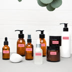 Flacons de cosmétiques ambrés et blancs étiquetés en rose : toner, essence, nettoyant et crème