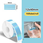 Rouleau d'étiquettes bleu clair irisé 12 × 40 mm et verre étiqueté Dad's Cup rincé sous le robinet