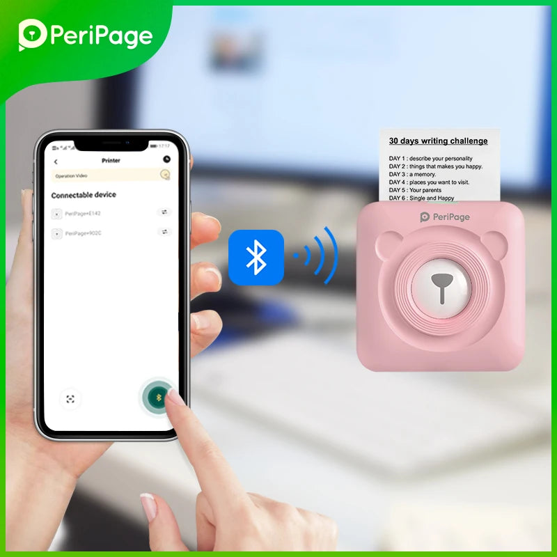 Main tenant un smartphone pendant l'appairage Bluetooth avec l'imprimante rose, qui imprime une liste « 30 days writing challenge »
