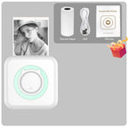 Contenu du coffret : mini imprimante blanche à anneau vert, rouleau thermique, câble USB et boîte cadeau