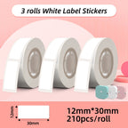 Trois rouleaux d'étiquettes blanches, format 12 x 30 mm, 210 pièces par rouleau, sur fond rose
