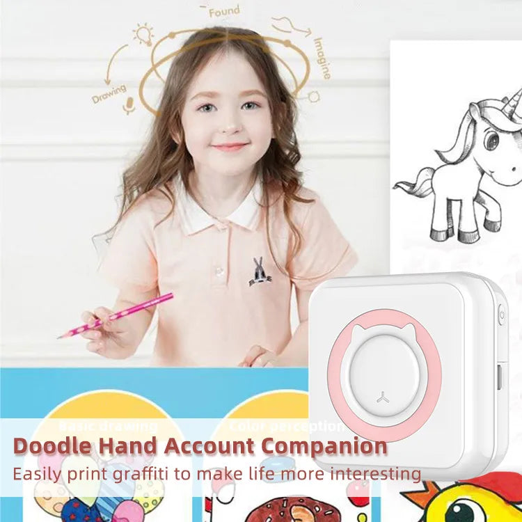 Petite fille souriante tenant un crayon rose devant un dessin de licorne imprimé, mini imprimante à anneau rose à droite