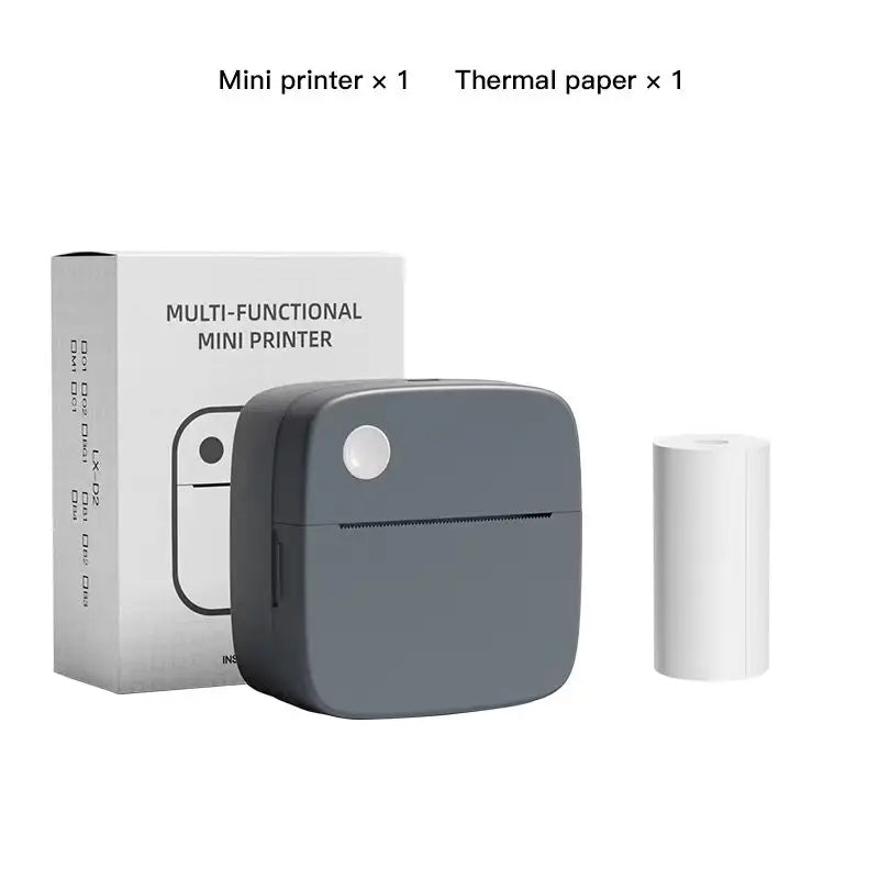 Imprimante gris anthracite à côté de sa boîte et d'un rouleau de papier thermique, sur fond blanc