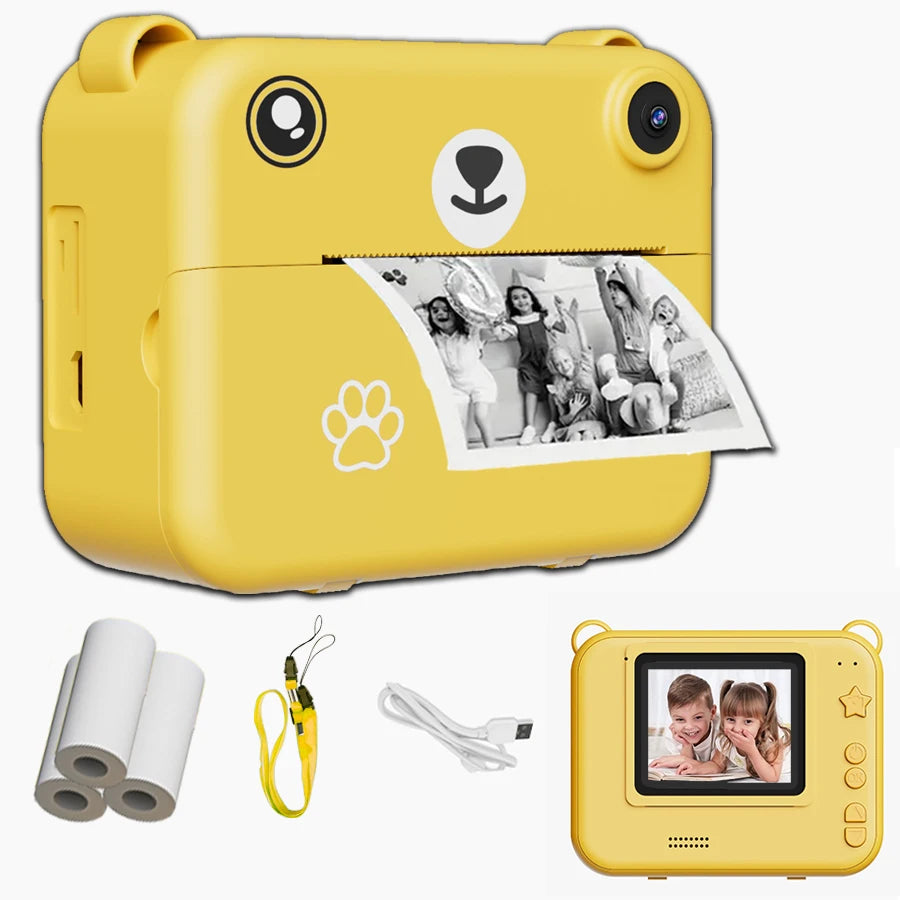 Appareil ourson jaune imprimant une photo d'enfants à une fête, avec rouleaux de papier, dragonne jaune, câble USB et vue de dos à l'écran allumé sur deux enfants