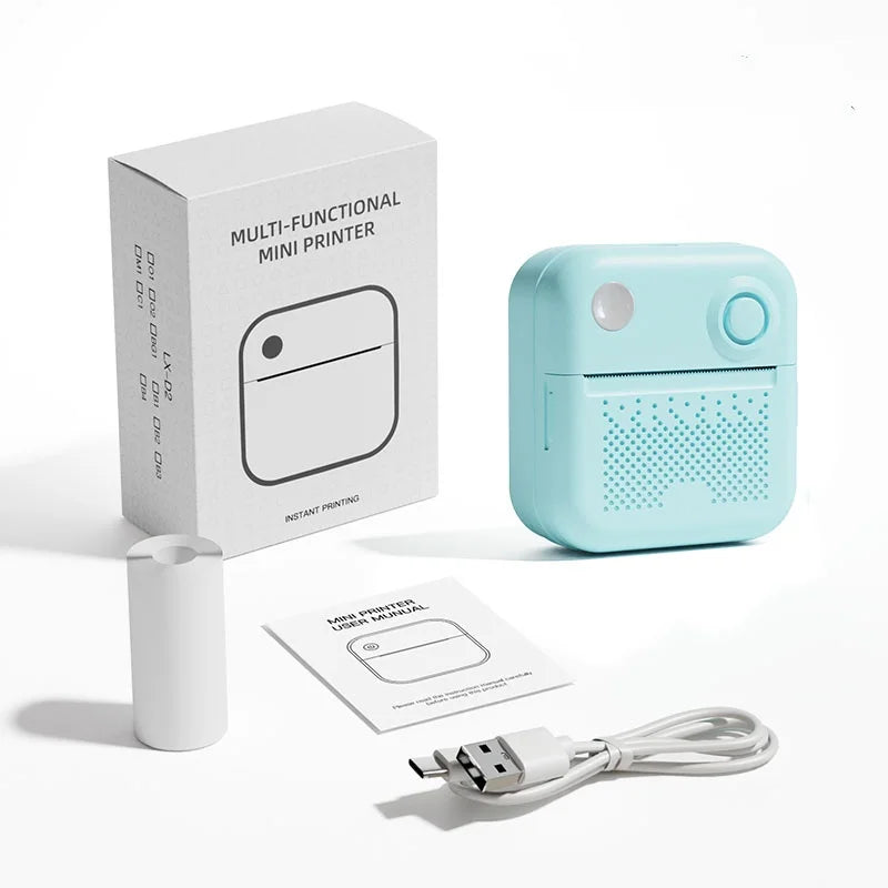 Imprimante bleu clair posée devant sa boîte, avec la notice, le câble USB et un rouleau de papier