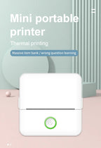 Imprimante thermique blanche posée sur un fond graphique rose et vert menthe aux formes géométriques