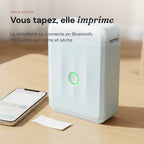 Imprimante à étiquettes enfant à côté d'un téléphone, étiquette imprimée posée sur la table