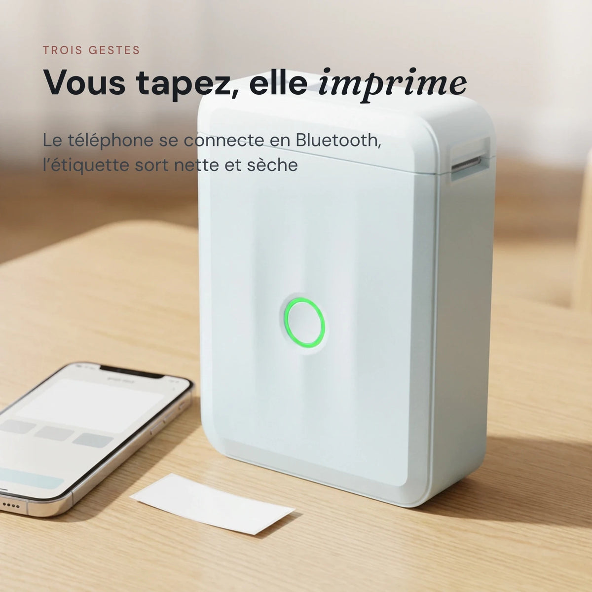 Imprimante à étiquettes enfant à côté d'un téléphone, étiquette imprimée posée sur la table