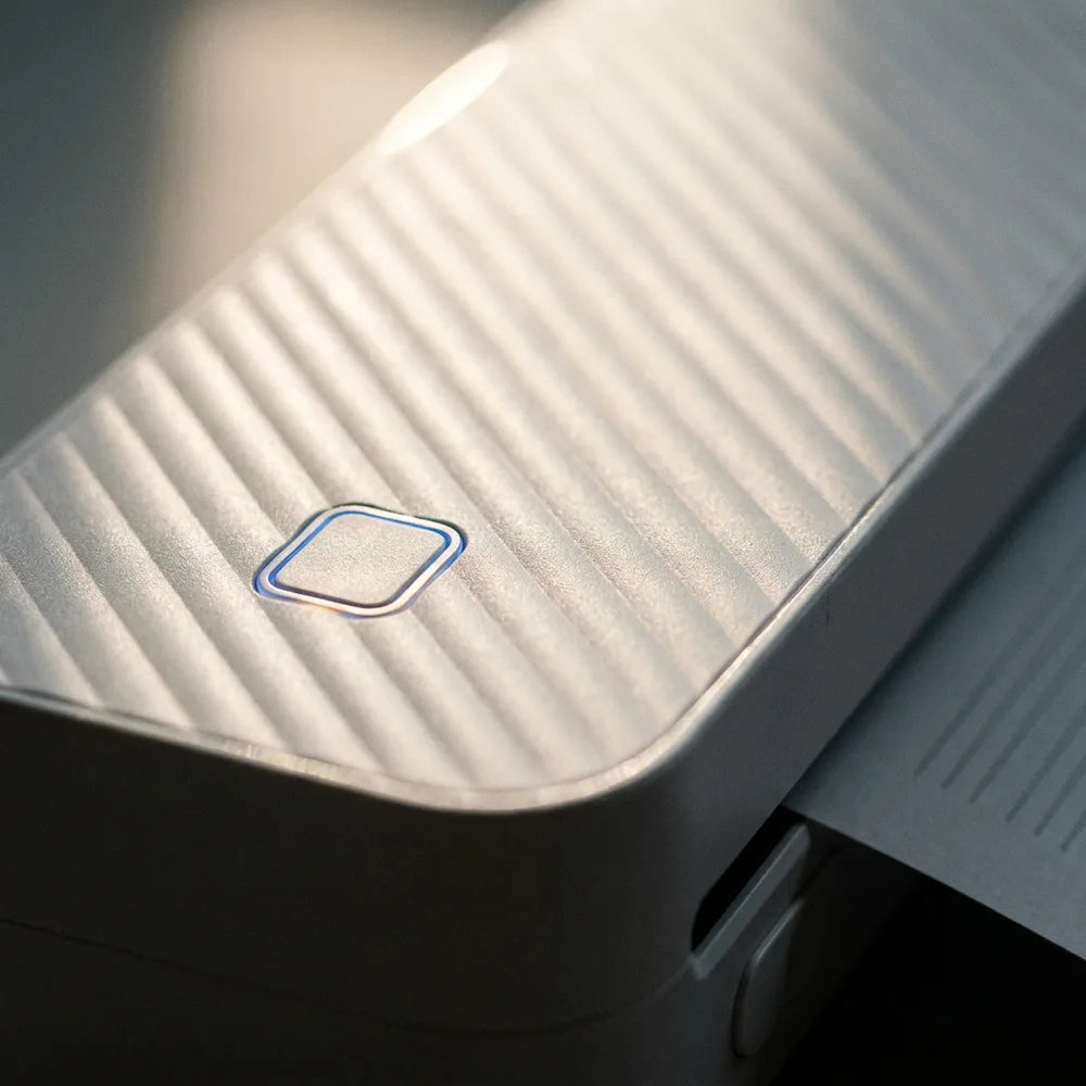Détail macro de la texture striée et du bouton LED de l'imprimante thermique A4