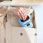 Imprimante thermique portable bleue compacte glissée dans un sac cabas en lin